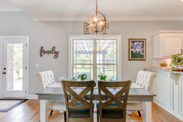 dining space featuring a chandelier, crown molding, and light wood finished floors