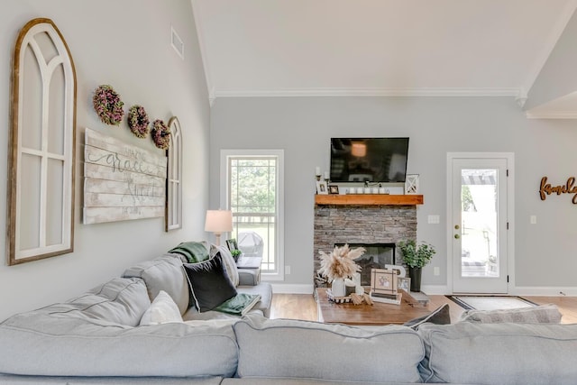 living room with crown molding, visible vents, wood finished floors, and a fireplace