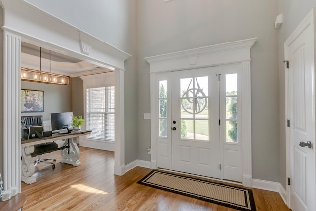 entryway featuring an inviting chandelier, baseboards, and wood finished floors