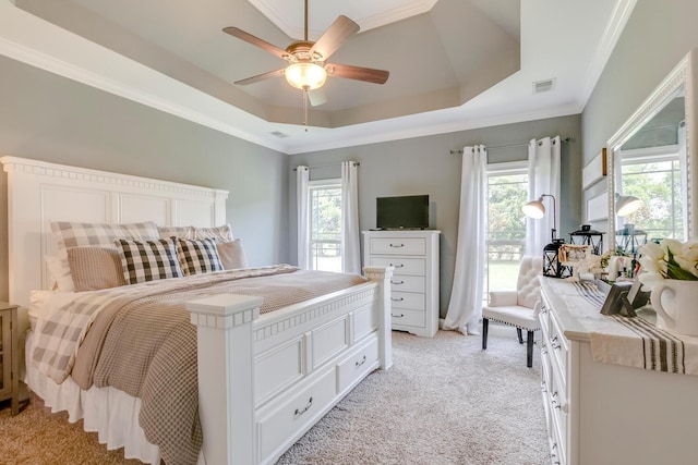 bedroom featuring light colored carpet, multiple windows, a raised ceiling, and ornamental molding