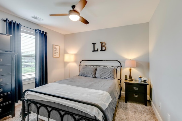 bedroom featuring visible vents, baseboards, a ceiling fan, and light carpet