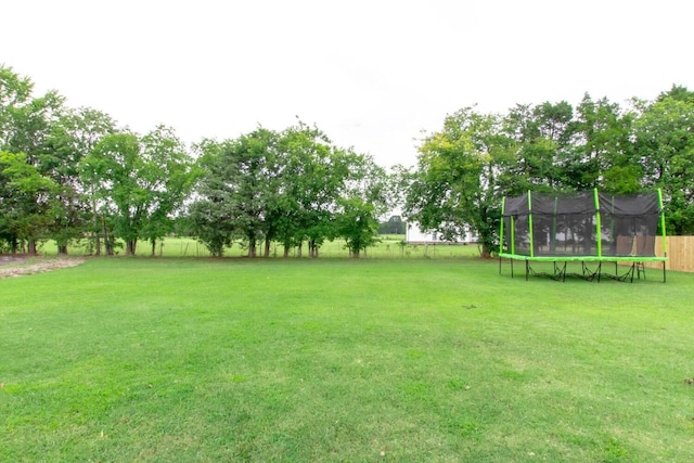 view of yard with fence and a trampoline