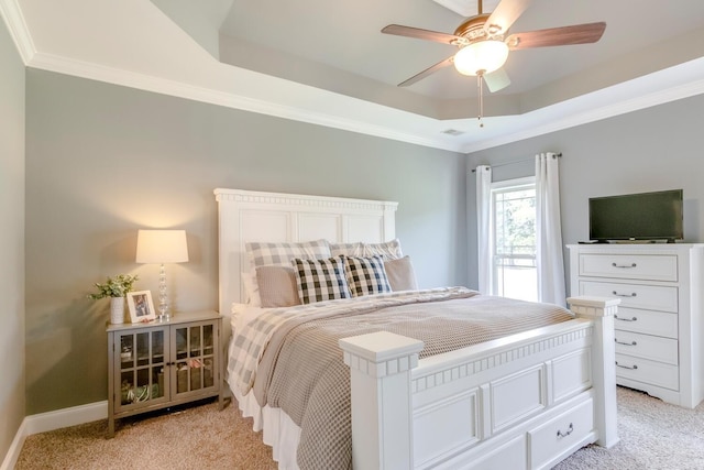 bedroom featuring a raised ceiling, ornamental molding, visible vents, and light colored carpet
