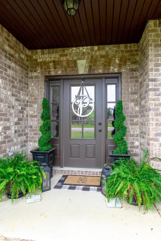 doorway to property with brick siding