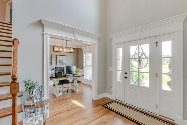 foyer featuring a wealth of natural light, stairway, and wood finished floors