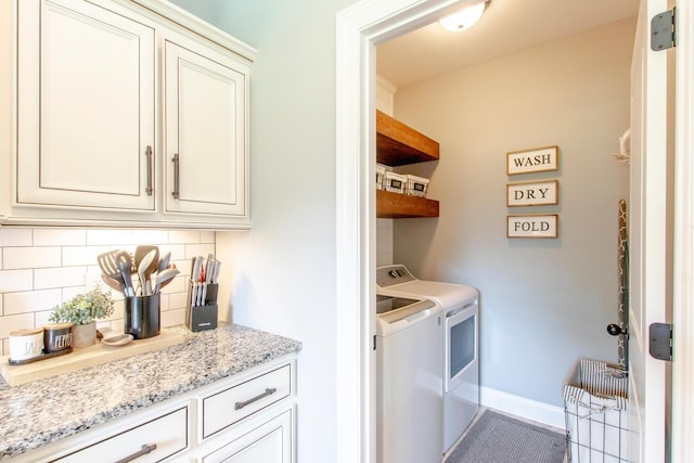 washroom featuring baseboards and washing machine and dryer