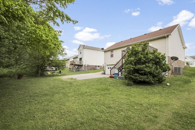 119 Sleepy Hollow Dr, Springfield, TN 37172 - view of grassy yard with a garage, driveway, stairway, central AC unit, and a wooden deck