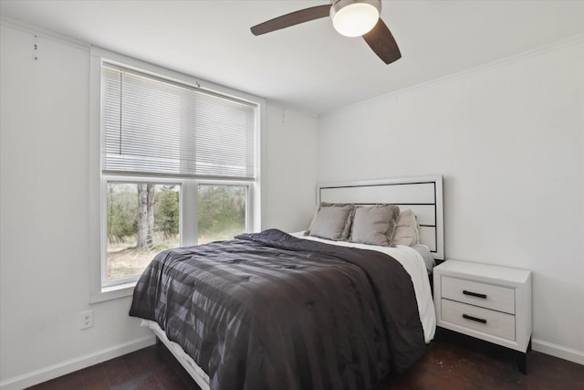 bedroom featuring ornamental molding, dark wood-style flooring, baseboards, and ceiling fan