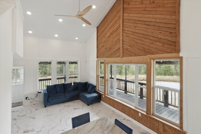living area featuring marble finish floor, a wealth of natural light, ceiling fan, and high vaulted ceiling