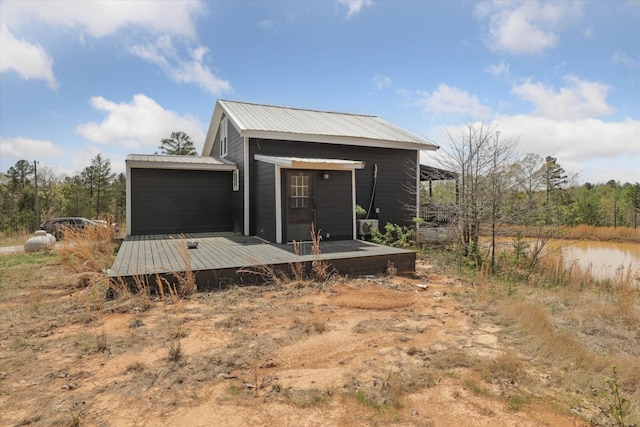 back of house featuring a deck and metal roof