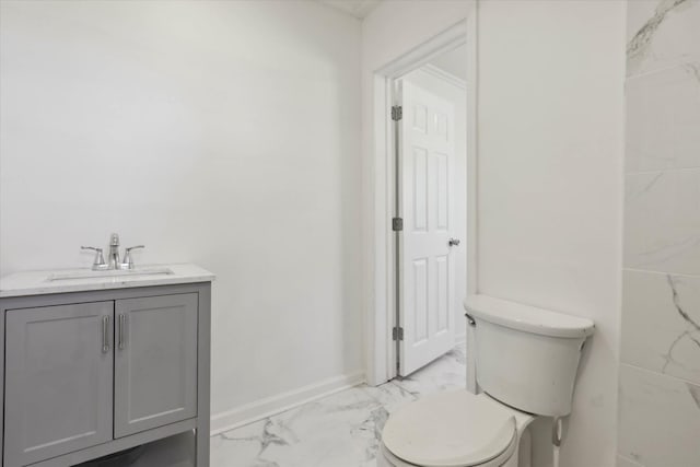 bathroom with toilet, baseboards, marble finish floor, and vanity