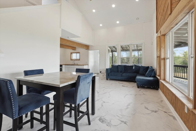 dining room with marble finish floor, recessed lighting, and a high ceiling