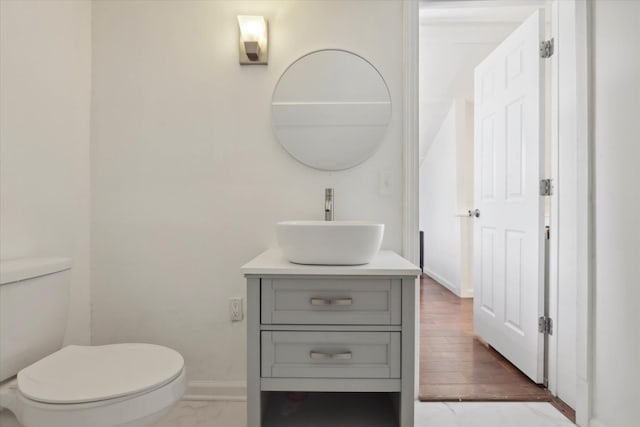bathroom featuring vanity, toilet, and baseboards