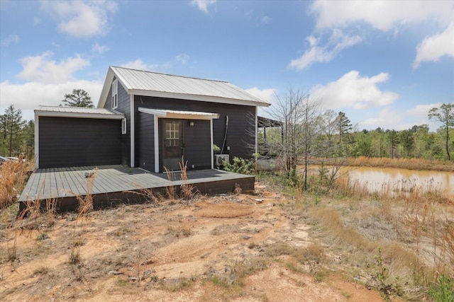 back of house with metal roof and a wooden deck