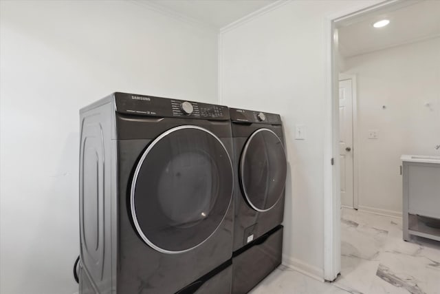 clothes washing area with baseboards, marble finish floor, washer and dryer, and crown molding