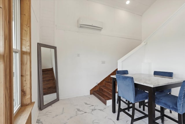 dining area featuring stairs, a wall unit AC, and marble finish floor