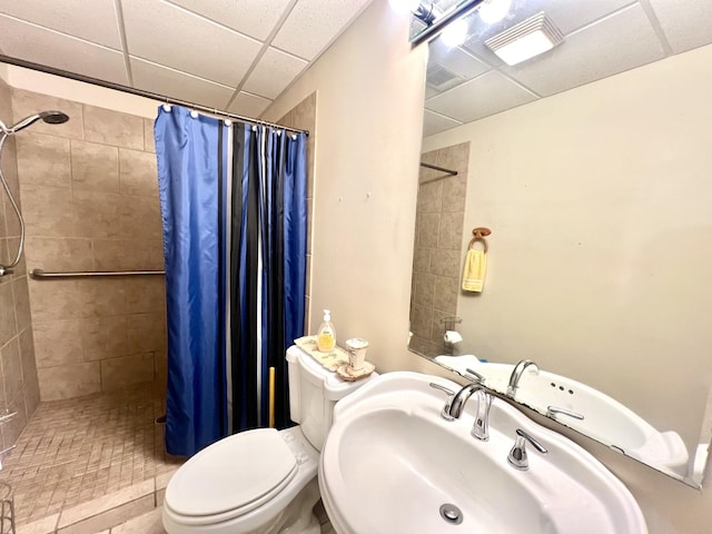 bathroom with a sink, toilet, visible vents, a paneled ceiling, and tiled shower