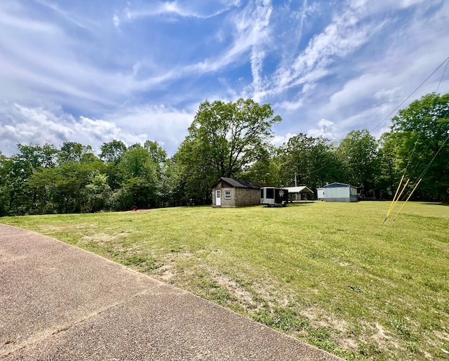 view of yard with a storage shed and an outbuilding