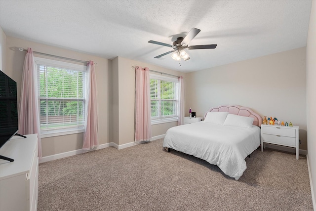 bedroom featuring multiple windows, carpet, baseboards, and a textured ceiling