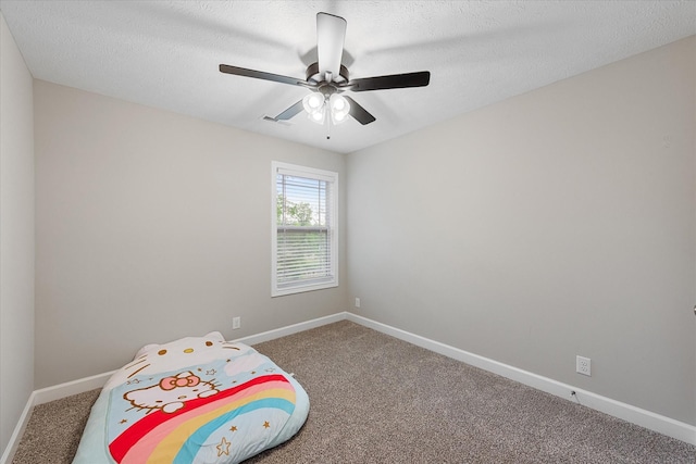 unfurnished bedroom featuring carpet floors, baseboards, a ceiling fan, and a textured ceiling