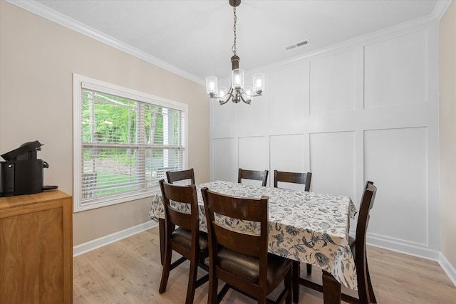 dining space with a chandelier, crown molding, light wood finished floors, and baseboards