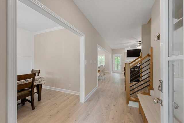 hall featuring stairs, light wood-style flooring, and baseboards