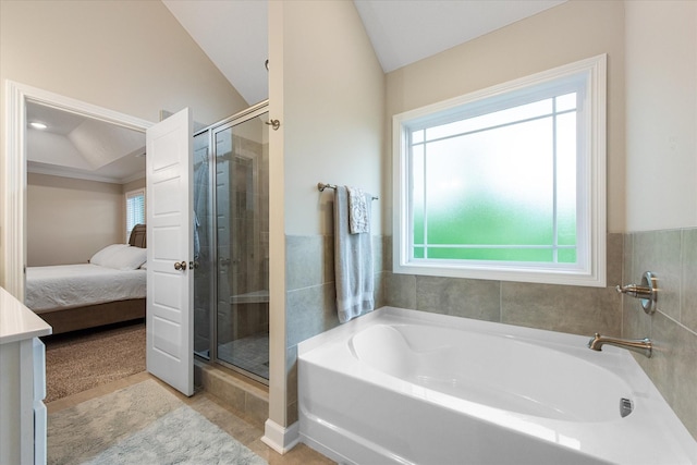 ensuite bathroom featuring a stall shower, a garden tub, vaulted ceiling, and tile patterned floors