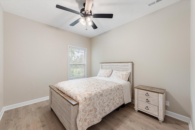 bedroom with light wood-style flooring, baseboards, and ceiling fan