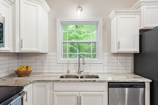 kitchen featuring dishwasher, a sink, white cabinetry, and backsplash