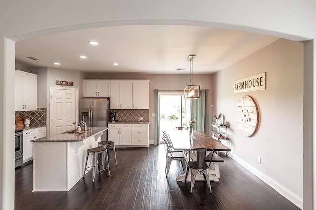kitchen with recessed lighting, white cabinets, appliances with stainless steel finishes, and decorative backsplash