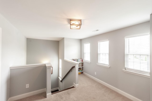 spare room with carpet flooring, baseboards, and visible vents