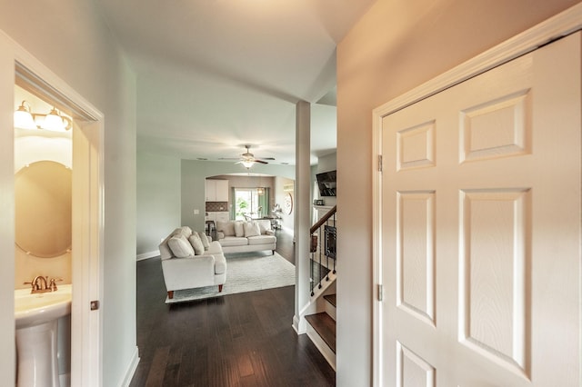 hall featuring stairway, baseboards, and dark wood-style floors