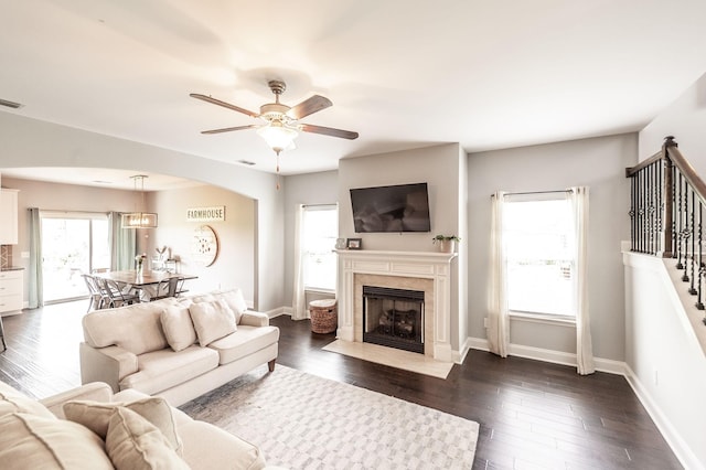 living room with stairway, baseboards, a ceiling fan, and a premium fireplace