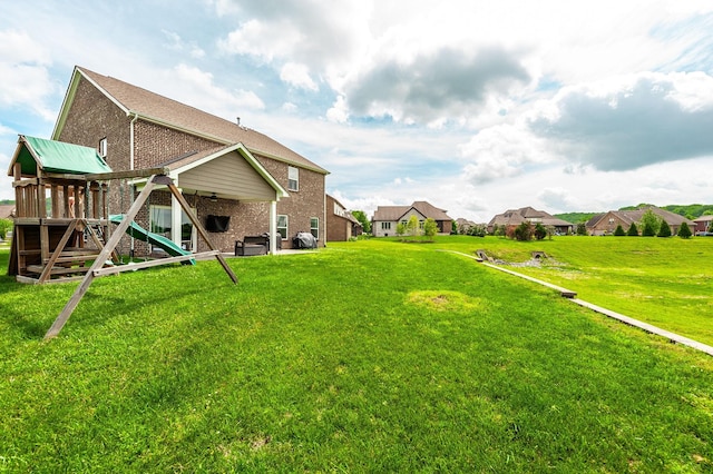 view of yard featuring a ceiling fan, a patio, a residential view, and a playground
