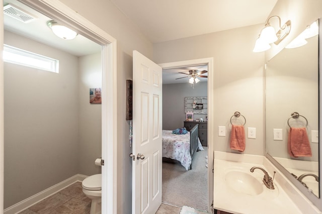 bathroom with toilet, a ceiling fan, visible vents, baseboards, and vanity