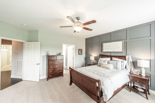 bedroom featuring a ceiling fan, baseboards, visible vents, and light colored carpet