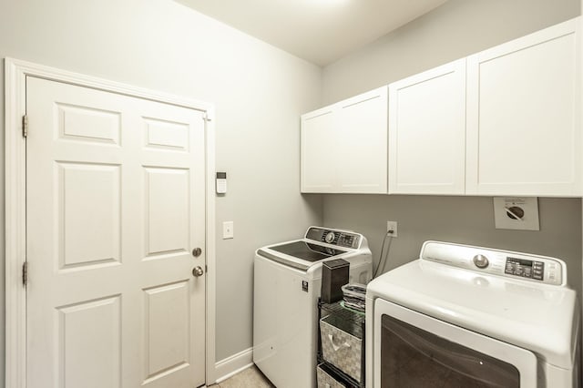 clothes washing area featuring cabinet space, separate washer and dryer, and baseboards