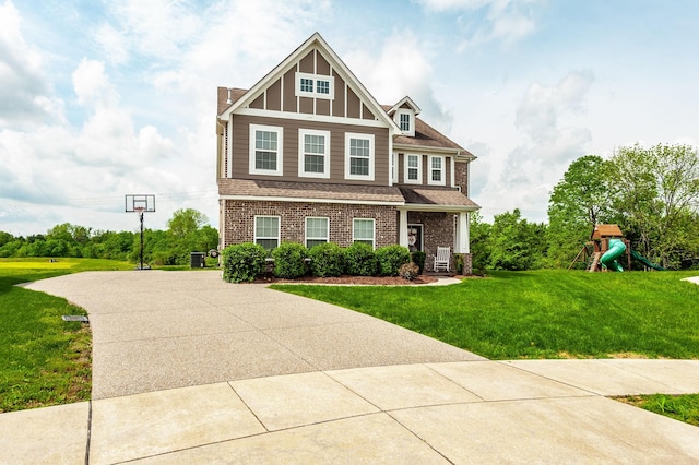 craftsman-style home featuring a front lawn, a playground, and brick siding