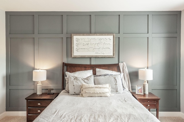 carpeted bedroom with a decorative wall and baseboards