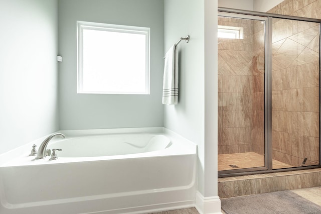 bathroom with a garden tub and a shower stall
