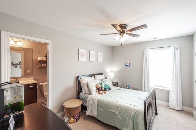 bedroom with ensuite bath, visible vents, ceiling fan, light carpet, and baseboards