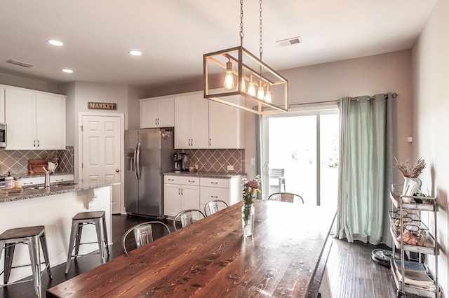 dining area featuring recessed lighting, dark wood finished floors, a chandelier, and visible vents