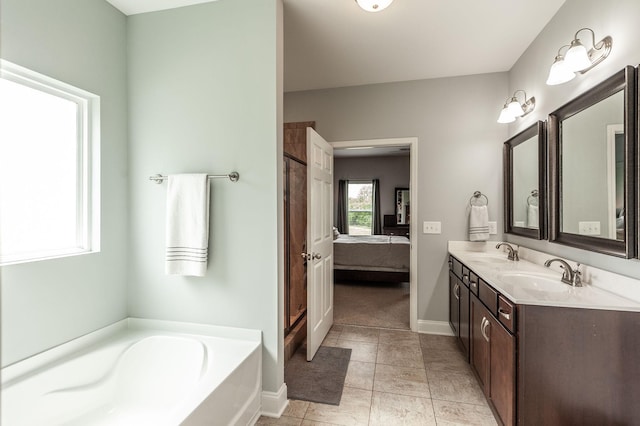 ensuite bathroom featuring a sink, connected bathroom, baseboards, and a garden tub