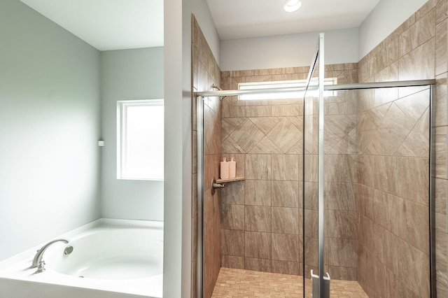 full bath with a bath, a wealth of natural light, and a shower stall