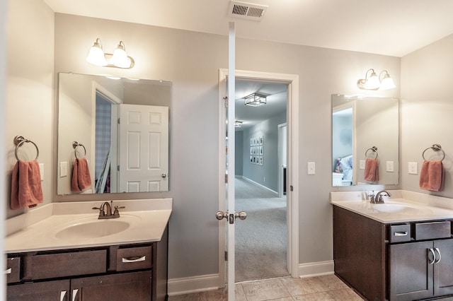 bathroom with a sink, two vanities, baseboards, and visible vents