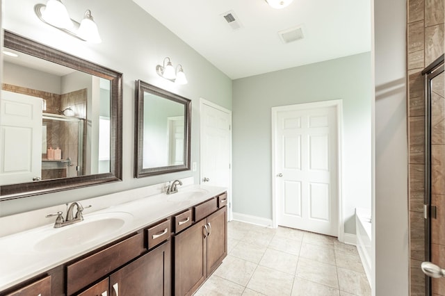 bathroom featuring a sink, tile patterned flooring, visible vents, and a tile shower