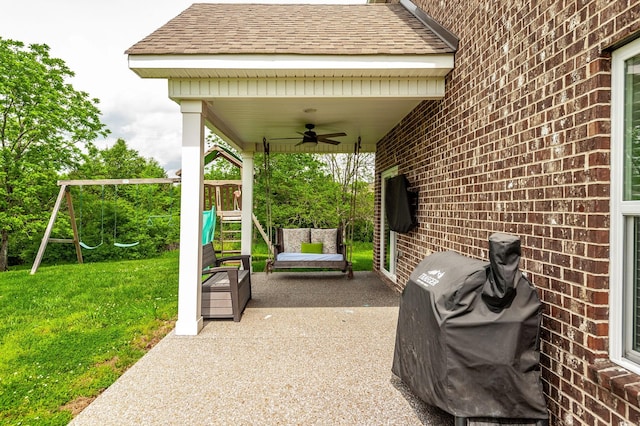 view of patio with area for grilling, a playground, and a ceiling fan