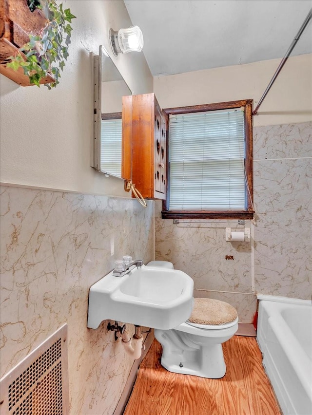 bathroom featuring a sink, toilet, a tub, and visible vents
