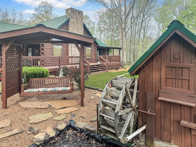 130 Wayne Threatt Rd, Dover, TN 37058 - view of side of home with a chimney, metal roof, covered porch, and log exterior