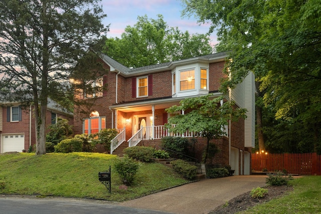 429 Old Oak Way, Hermitage, TN 37076 - traditional-style home with an attached garage, concrete driveway, covered porch, brick siding, and stairway